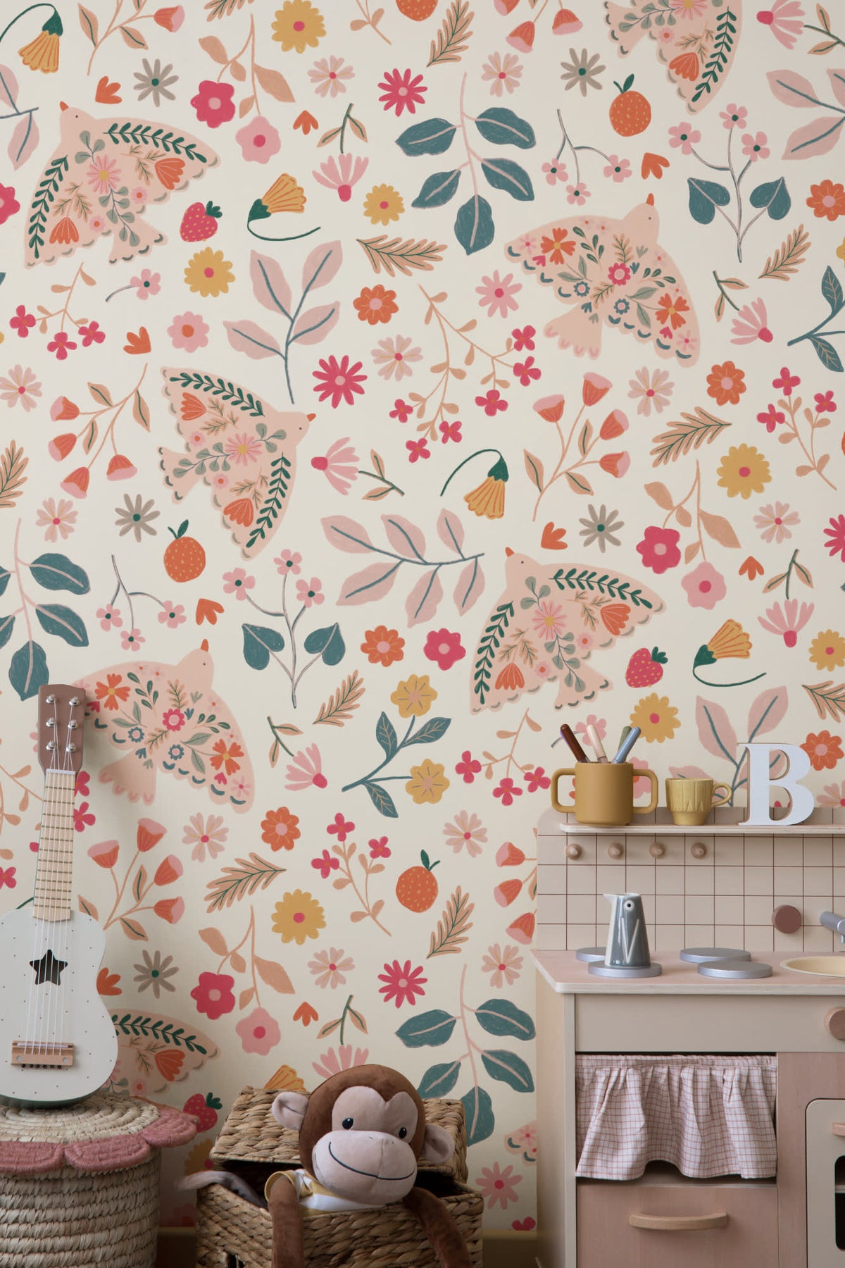 The Songbird Parterre wallpaper in blush and coral in a child's bedroom