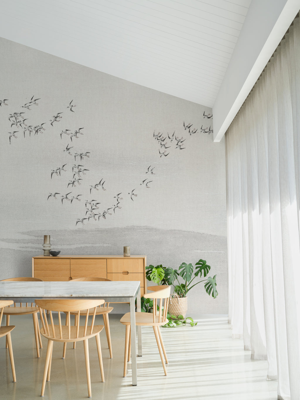 The Starling Murmuration mural in mist grey and oat behind a dining table
