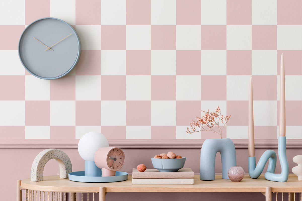 The Sugar Check wallpaper in candy pink and white as a backdrop to styled furniture