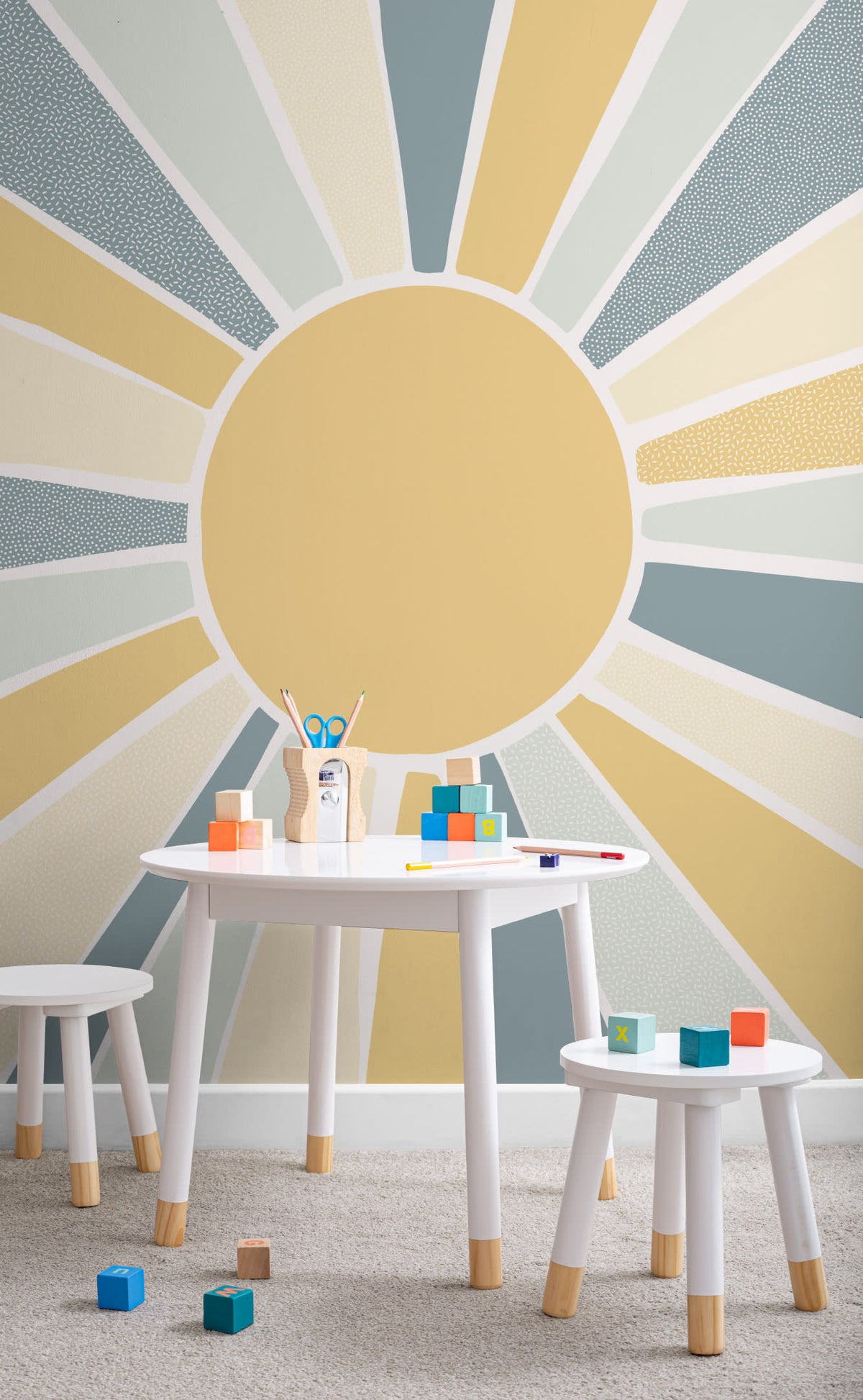 The Sunburst Morning mural in dusty blue and mustard in a children's room setting