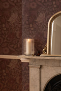 The Thistle Manor wallpaper in mulberry plum in a living room