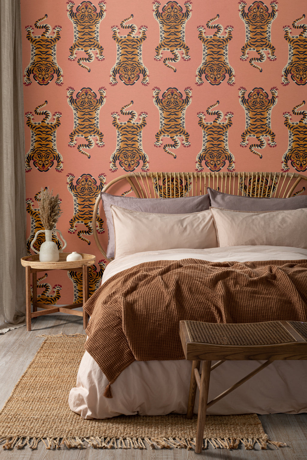 The Tiger Court wallpaper in coral and amber behind the bed in a bedroom