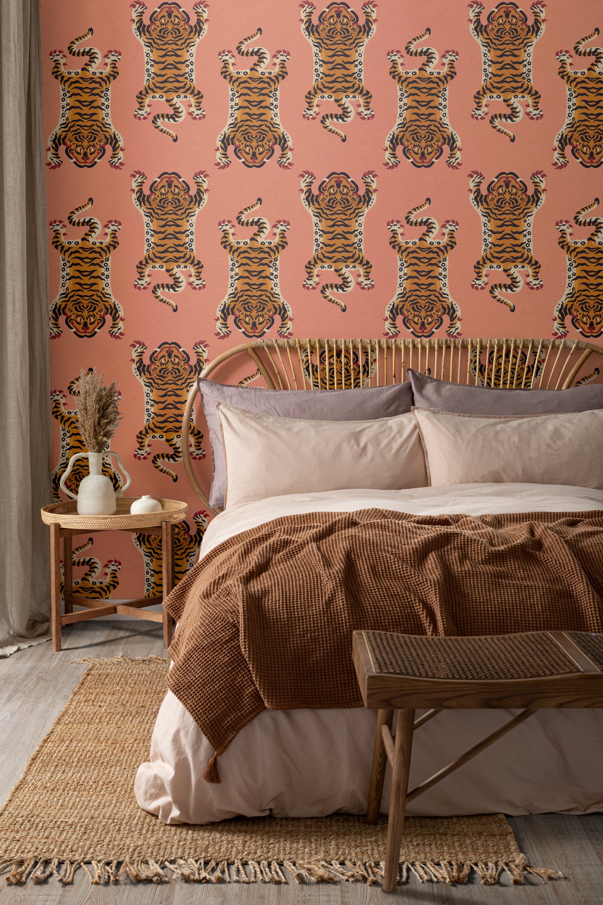 The Tiger Court wallpaper in coral and amber behind the bed in a bedroom