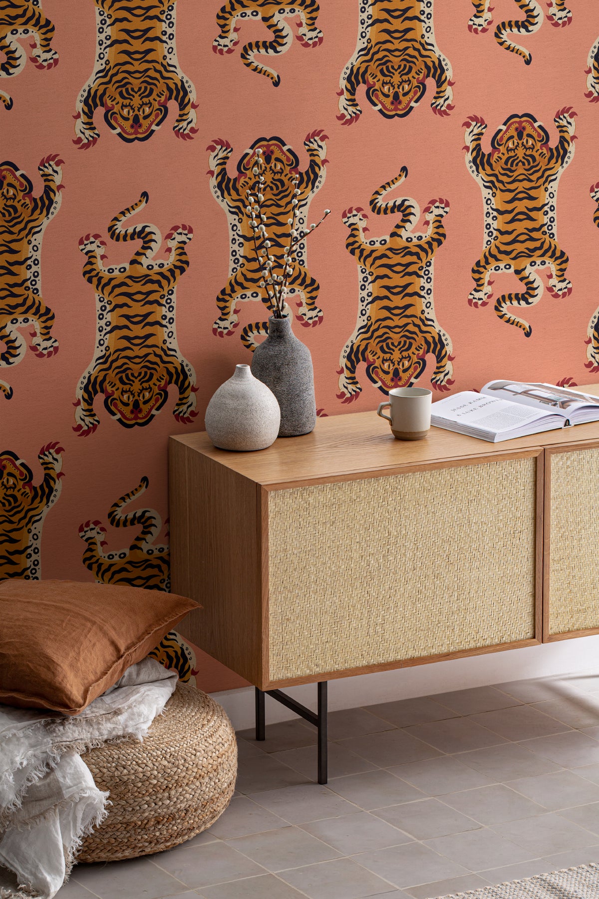 The Tiger Court wallpaper in coral and amber as a backdrop to styled furniture