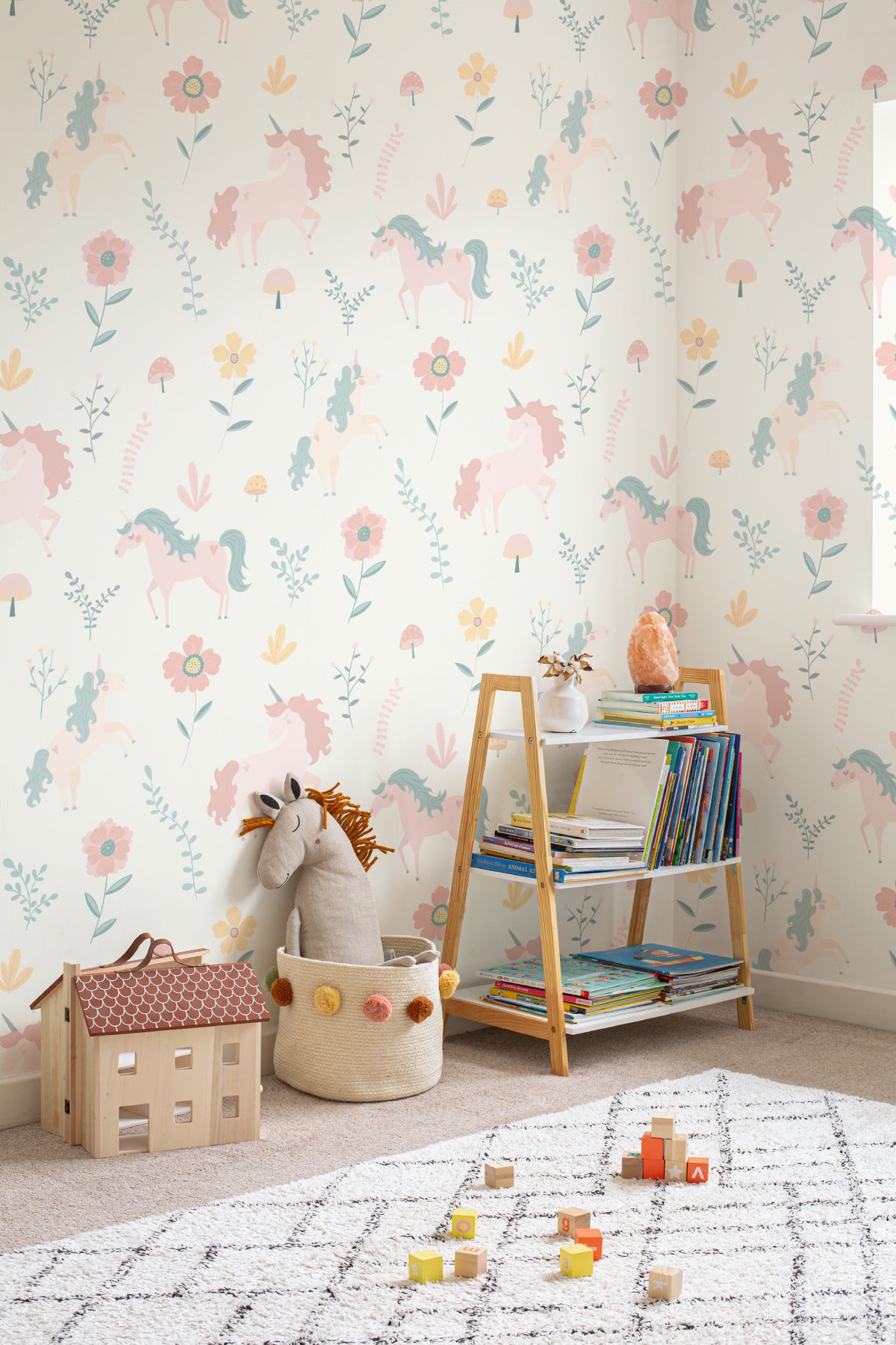 The Unicorn Garden wallpaper in soft pastel behind a kids' play corner