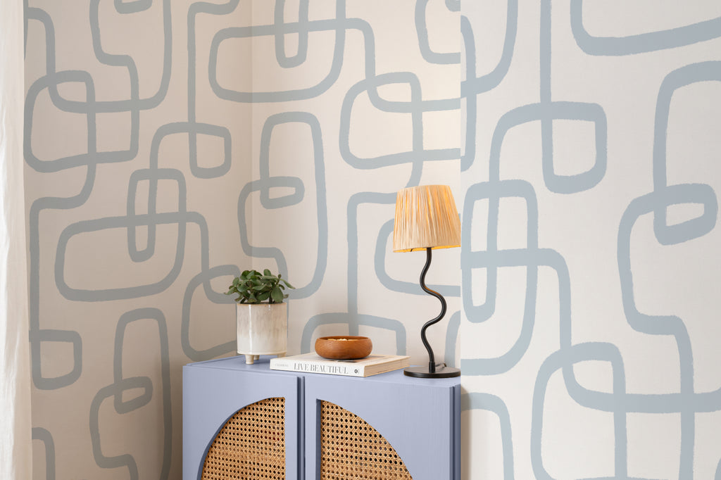 The Wandering Line wallpaper in pale blue behind a styled console