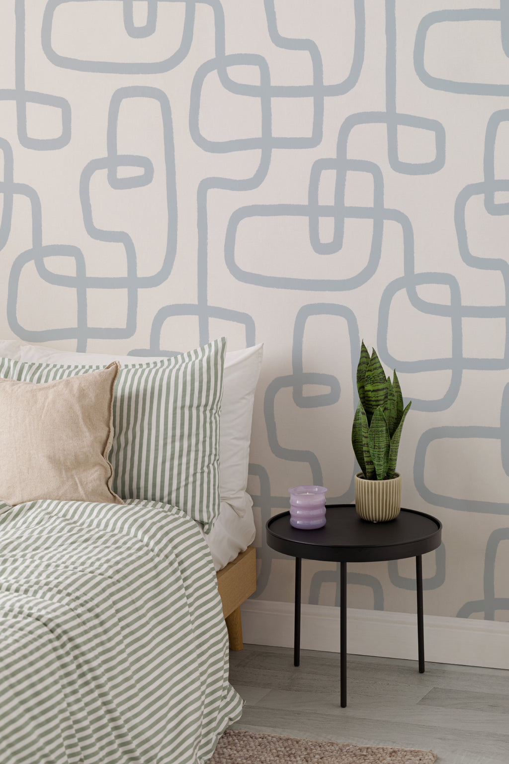 The Wandering Line wallpaper in pale blue behind the bed in a bedroom