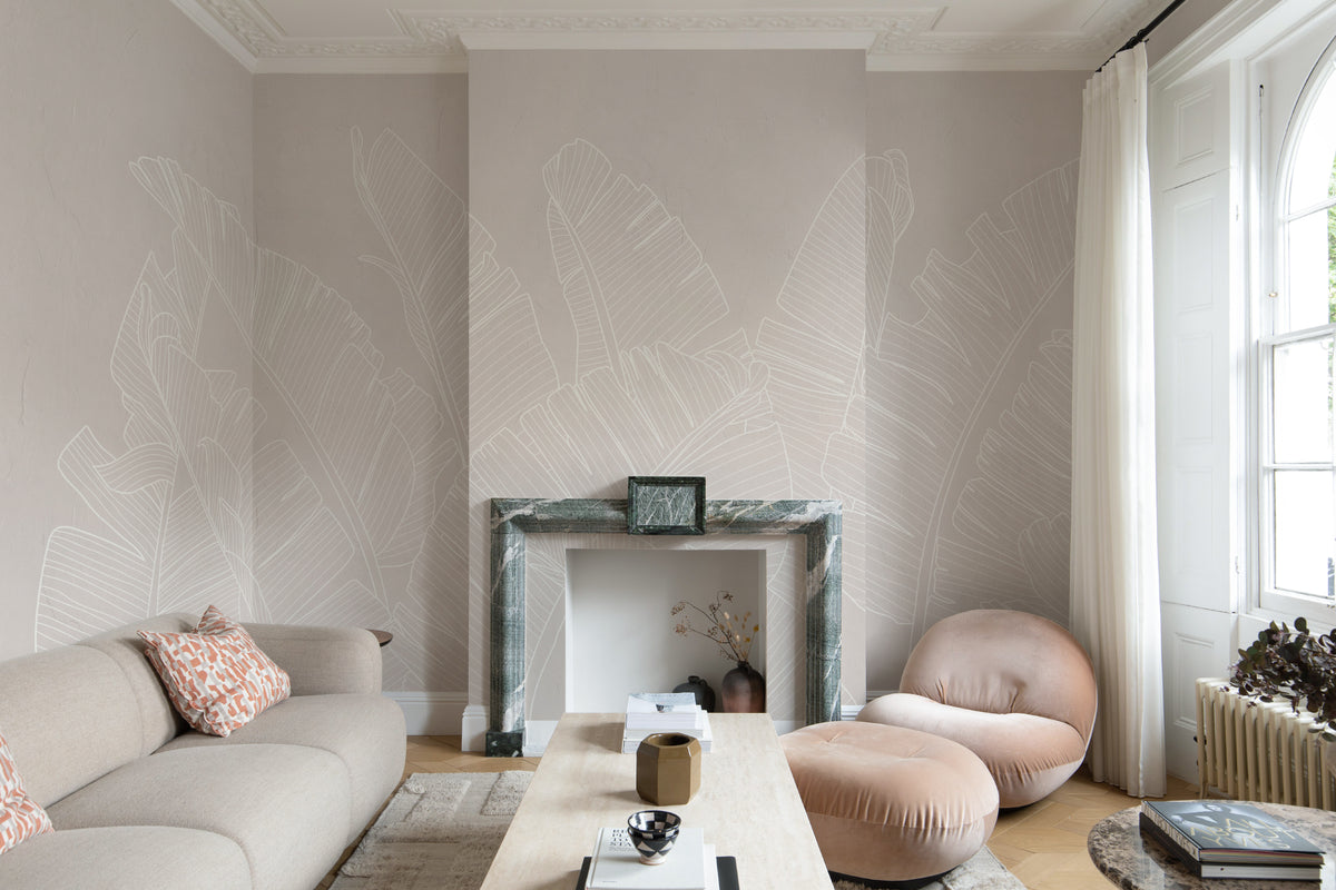 The Whisper Leaf mural in pale oat behind seating in a living room